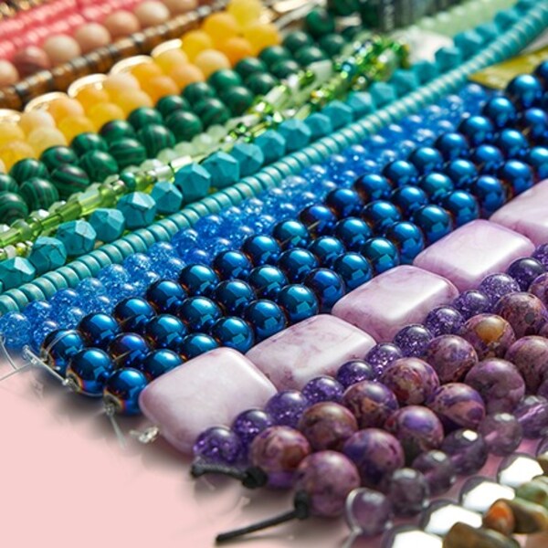 strung beads in different sizes in rainbow order